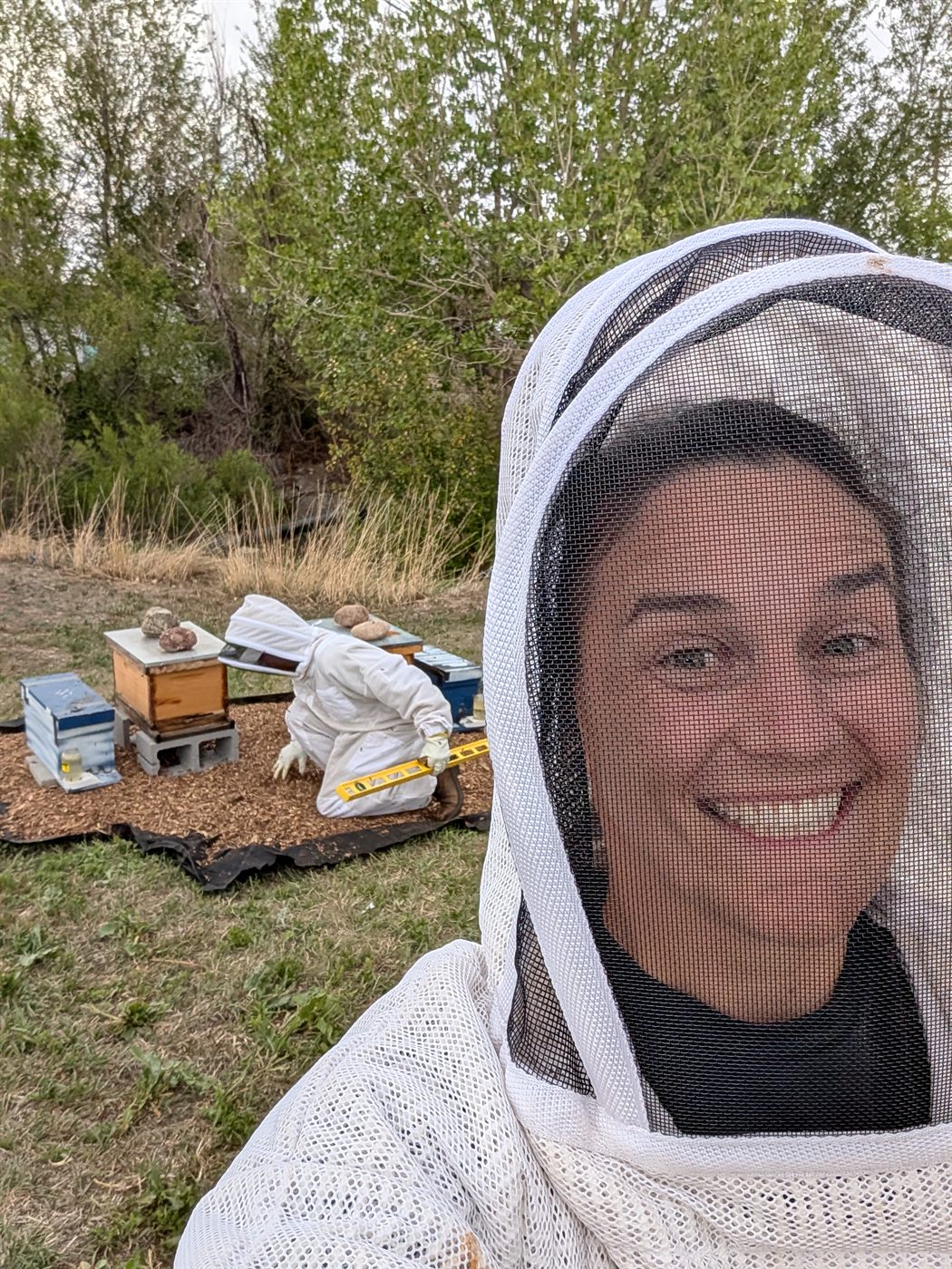 Elly Kirkhoff tending beehives — hands-on regenerative farming and agritourism experiences on the Colorado Front Range